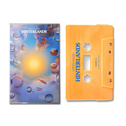 Hinterlands cassette tape in orange with artistic cover featuring water droplets and blurred light background