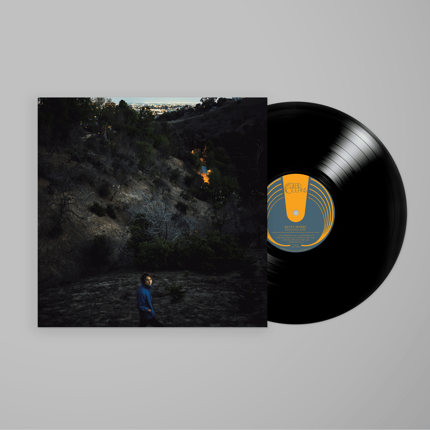 Vinyl record and album cover of Singing Saw featuring a person standing on a dark hillside at dusk.