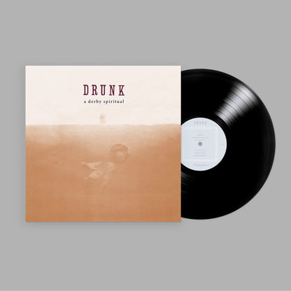 A vinyl record and album cover with the title DRUNK displayed above the text A Derby Spiritual.