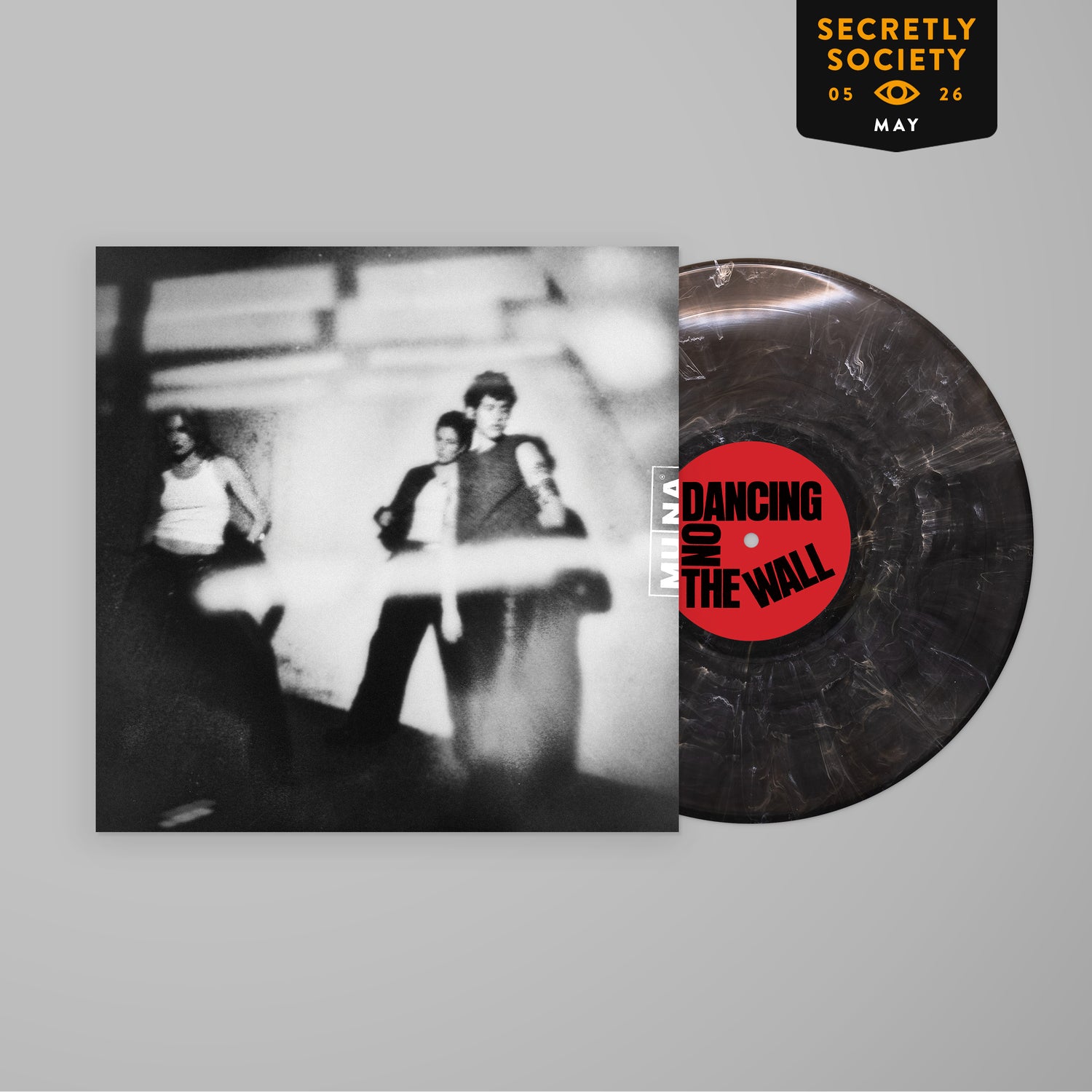 Black and white blurred photo of four people on an album cover next to a marbled vinyl record with a red label reading Dancing on the Wall